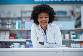 Happy Pharmacist resting elbows on counter