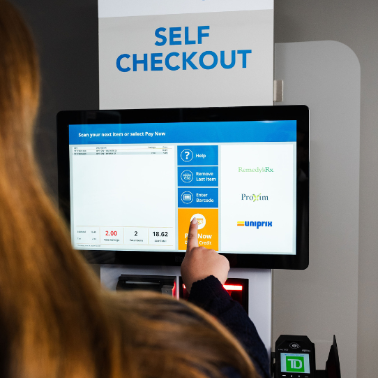 Woman with long hair removing a receipt from a self-checkout